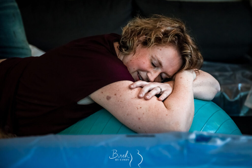 Thuisbevalling met bevalbal moeder met weeen op de grond foto door geboortefotograaf amesfoort