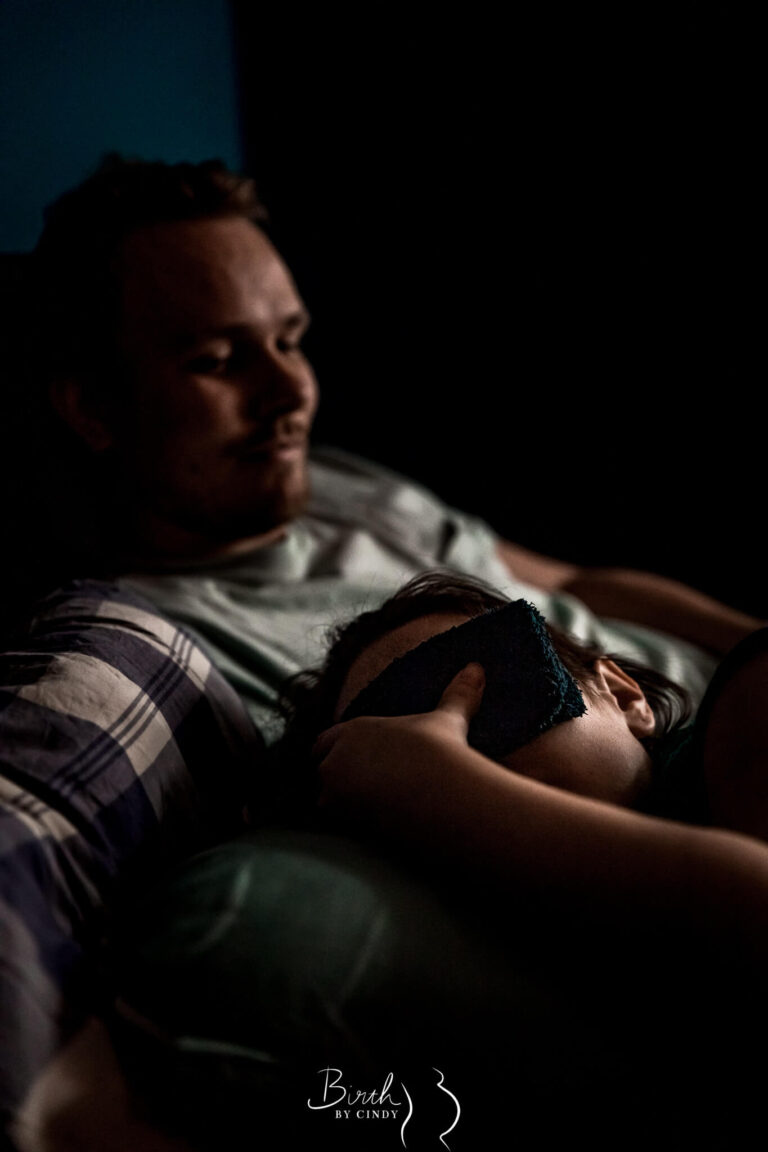 thuisbevalling op bed met vrouw vangt weeen op en partner kijkt toe door geboortefotograaf amersfoort amsterdam